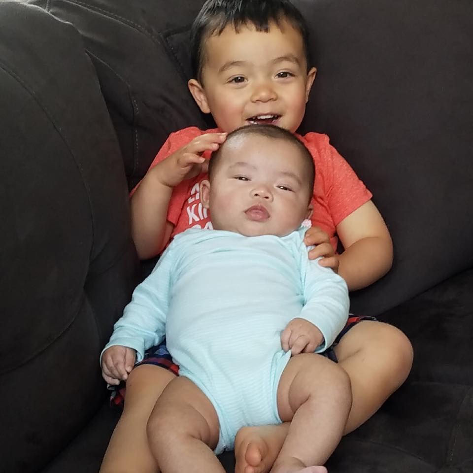 Two siblings sitting together on a couch