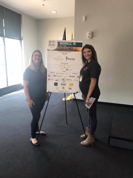 author standing near a poster with another advocate