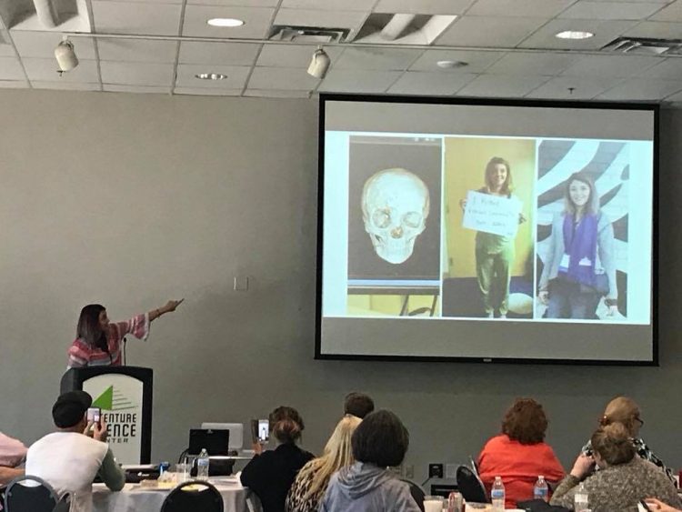 author speaking with a slideshow in the background