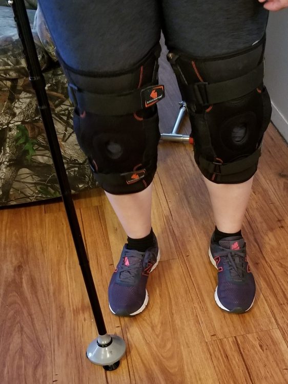 legs with knee braces on both and cane