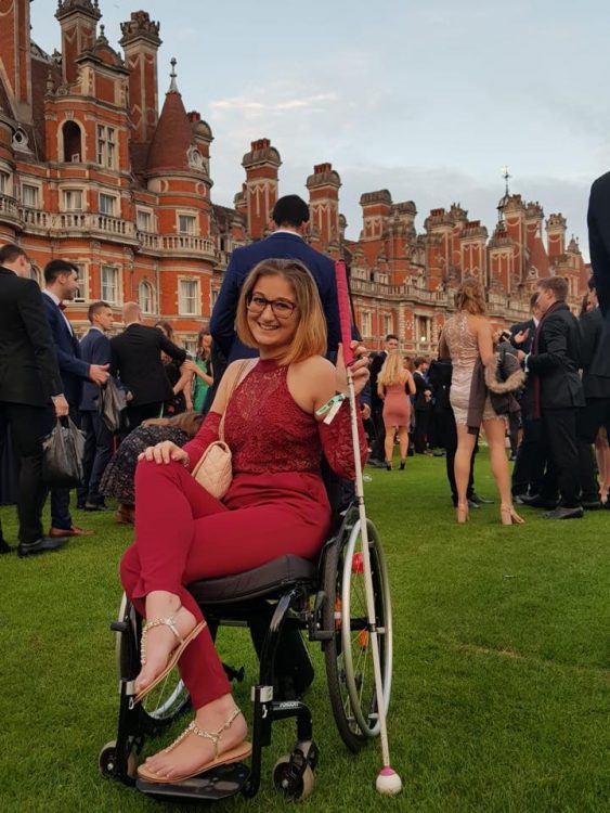 woman in wheelchair holding white cane