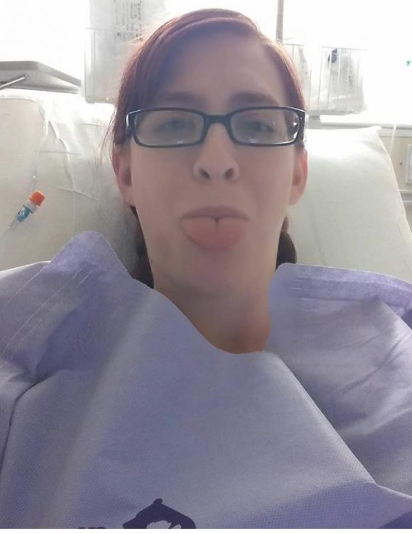 woman wearing paper gown and sticking her tongue out