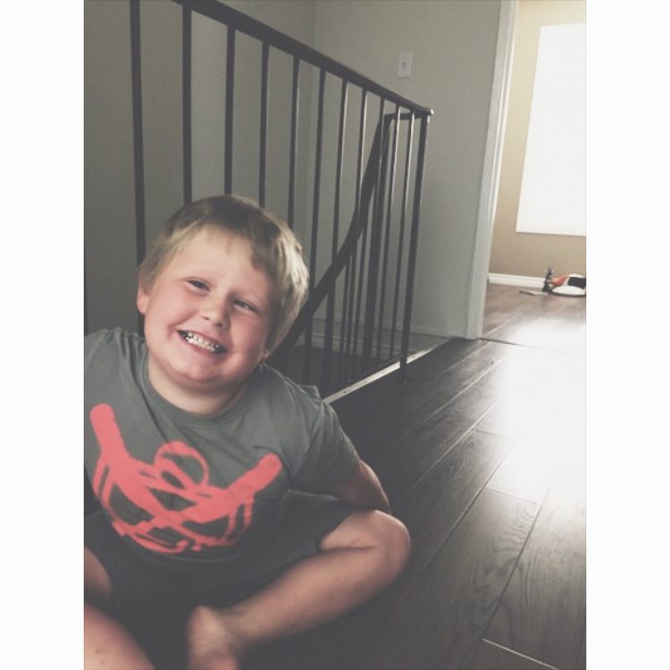 Child sitting on floor smiling at camera