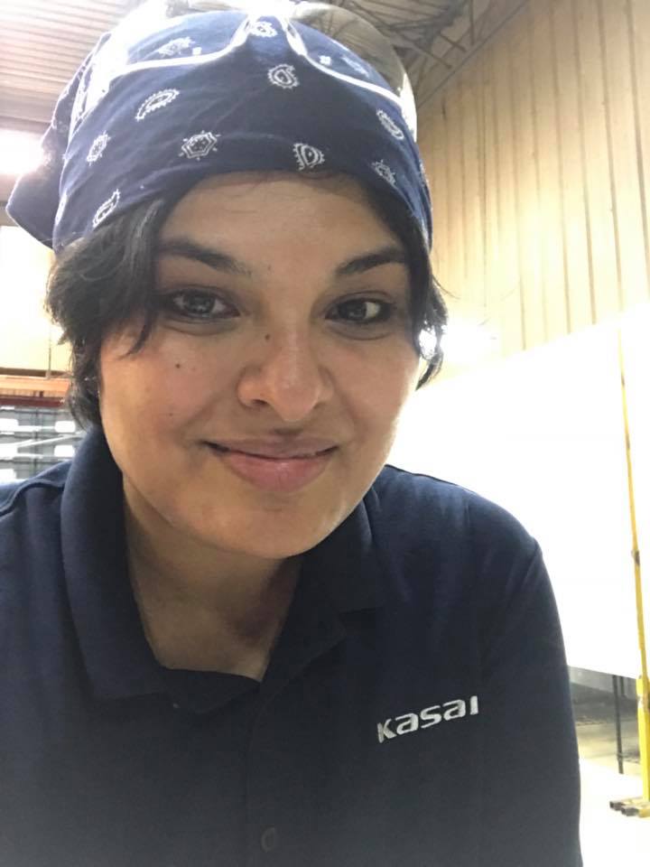 woman wearing work attire including bandana and safety glasses