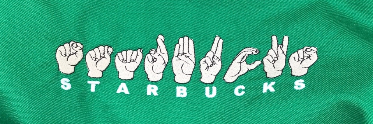 Starbucks apron with the word "Starbucks" in fingerspelling.