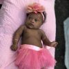 Baby girl with Down syndrome wearing pink tutu and pink headband
