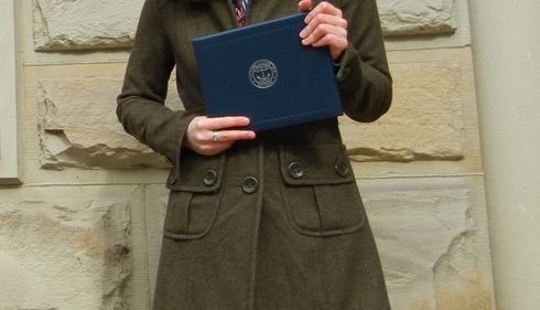 author holding her degree in her hand