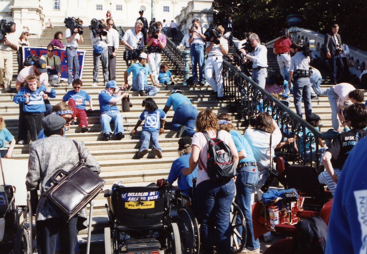 Disability rights activists crawl up the Capitol steps to demand passage of the ADA.