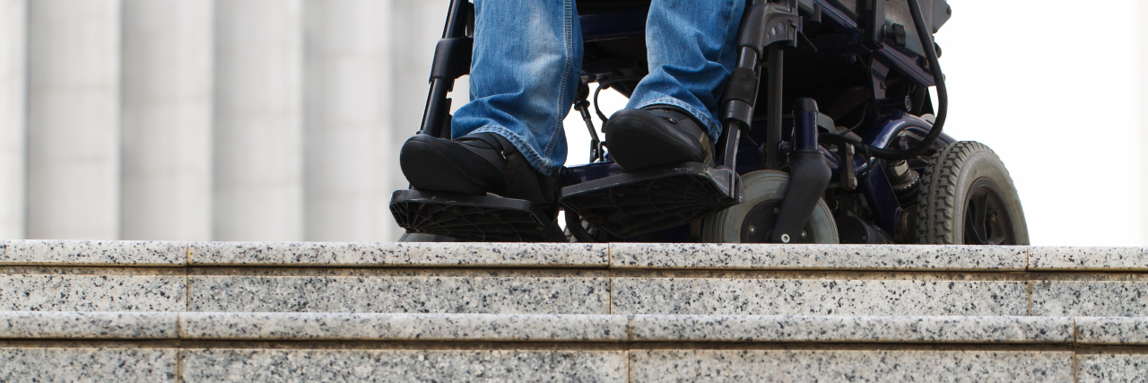 Wheelchair user in front of staircase.