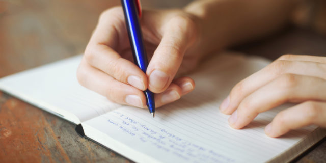 How a Diary Could Help If You're Experiencing PTSD a person's hands writing in a diary