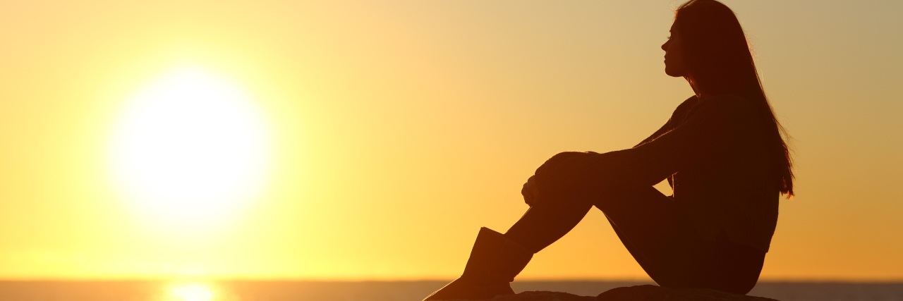 Why Solar Urticaria Doesn't Have to Define You Profile of a woman silhouette watching sun on the beach at sunset