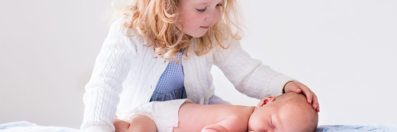 When My Little Brother Was Born With Down Syndrome Little sister hugging her newborn brother.