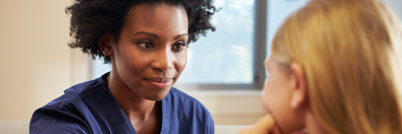 A nurse talking with a patient.