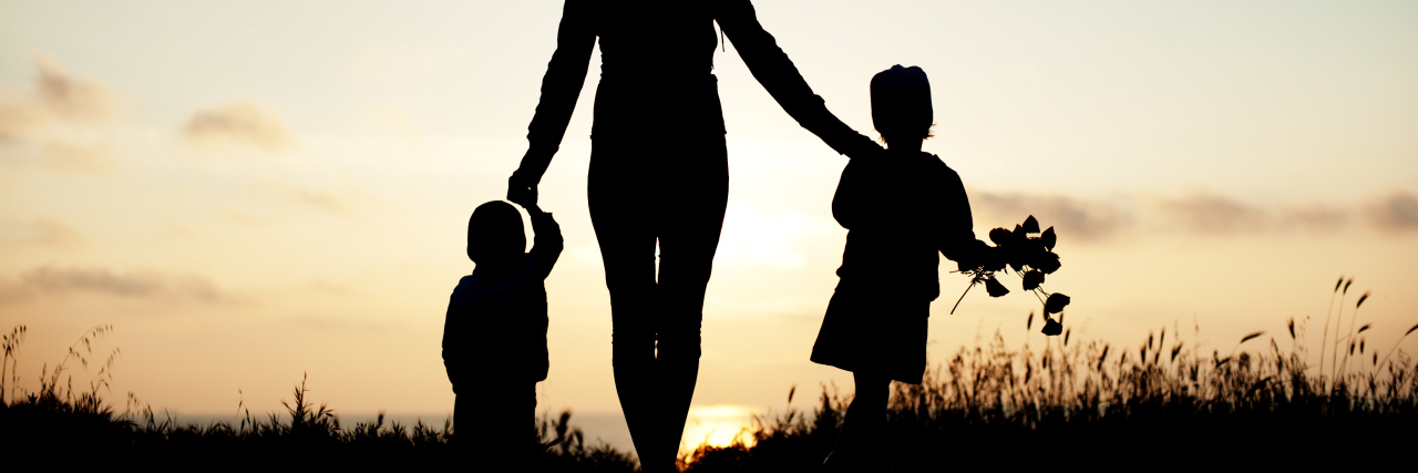 When a Breast Cancer Diagnosis Strikes in Your 30s A mother holding the hands of her children