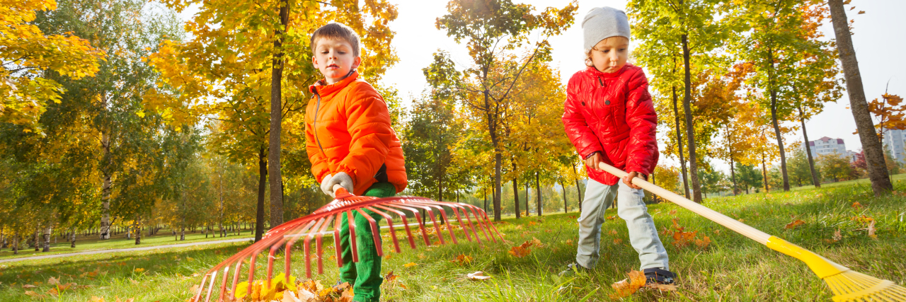 Boy and girl raking leaves.