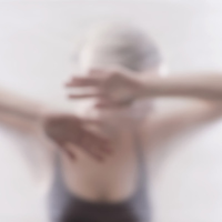 A woman behind a plastic wall, her head resting on her arms.