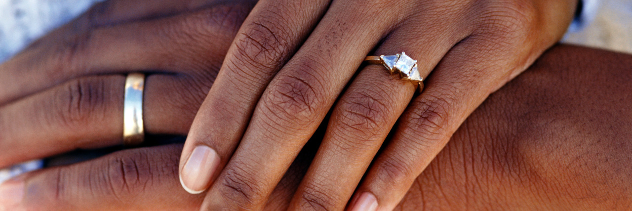 Losing Disability Health Care Because of Marriage Hands of married couple wearing wedding rings.