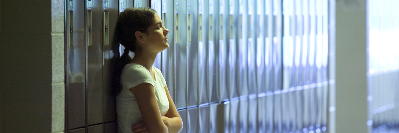 Getting School Time-Outs as an Undiagnosed Autistic Child Girl standing by lockers at school.