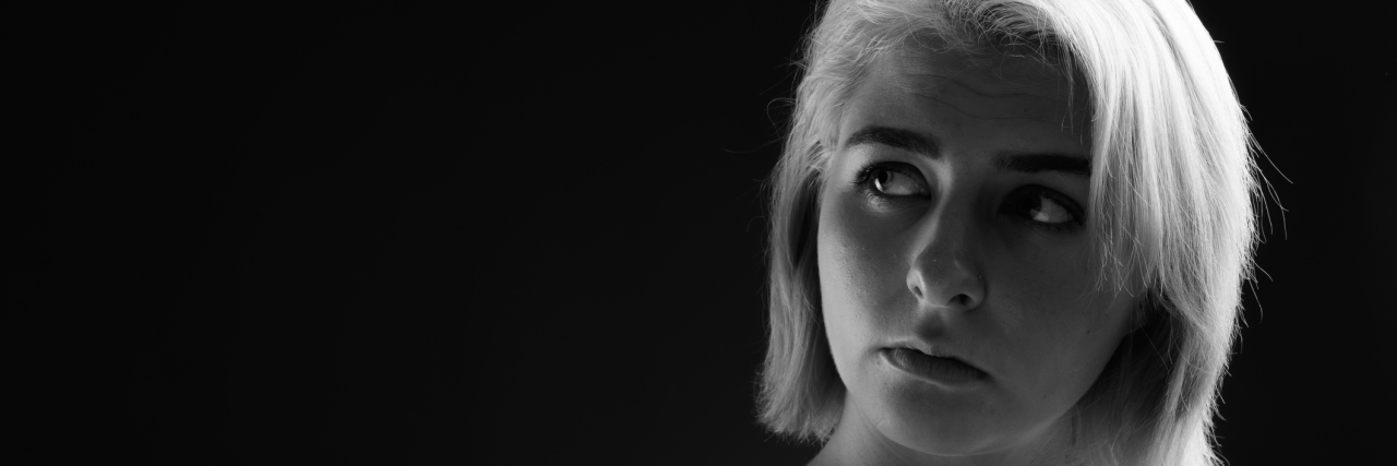 What I've Had to Consider as I Decide If I Should Get a Hysterectomy A black and white image of a woman looking up, deep in thought.