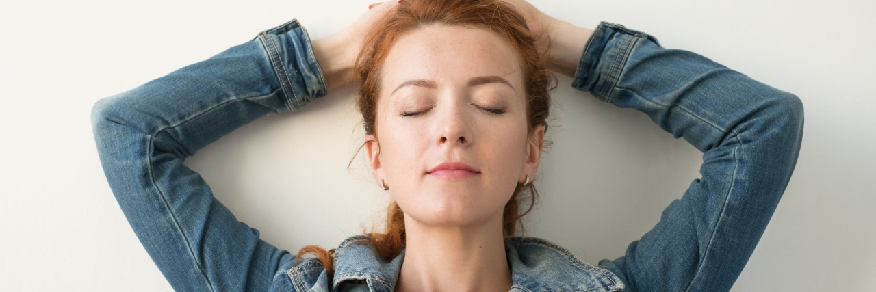 How Grief and Fibromyalgia Have Pushed Me to Become My Own Hero woman with hands behind her head with her eyes closed