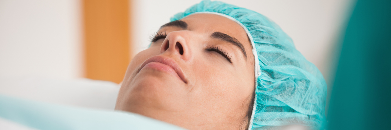 Patient lying on a hospital bed, going into surgery.