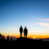 A team of climbers looking at the sunset.