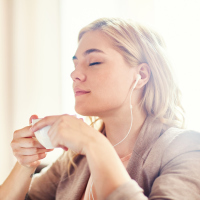 woman listening to music and drinking tea