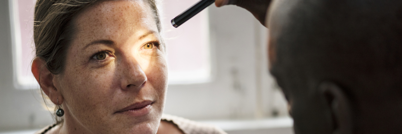 When My General Practitioner Left and It Was Time to Find a New Doctor A picture of a doctor shining a light into his patient's eyes.