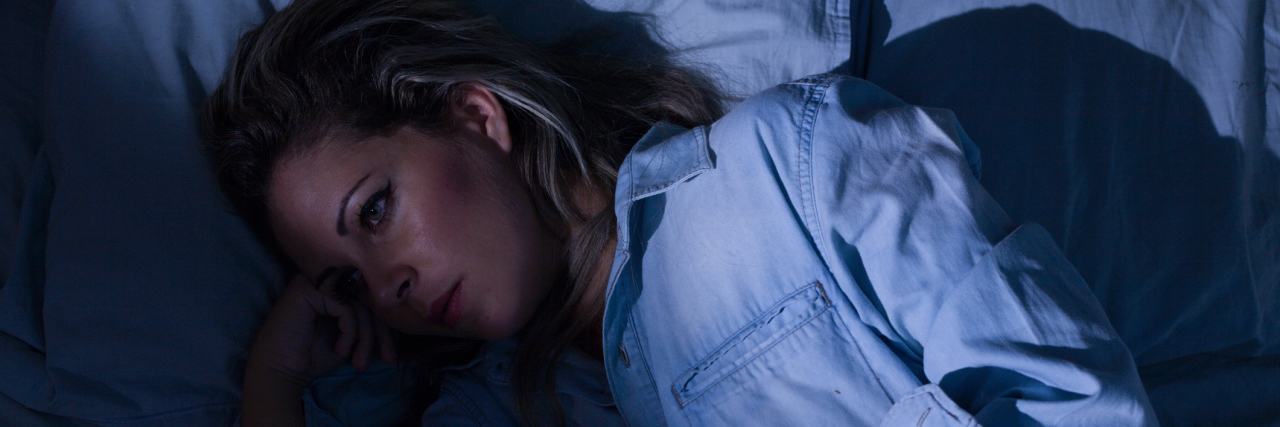 When I Thought I Lost Me to ME A woman laying awake in a dark room.