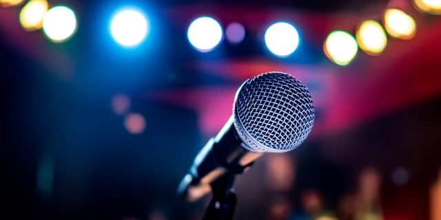 Microphone on stage against a background of auditorium.