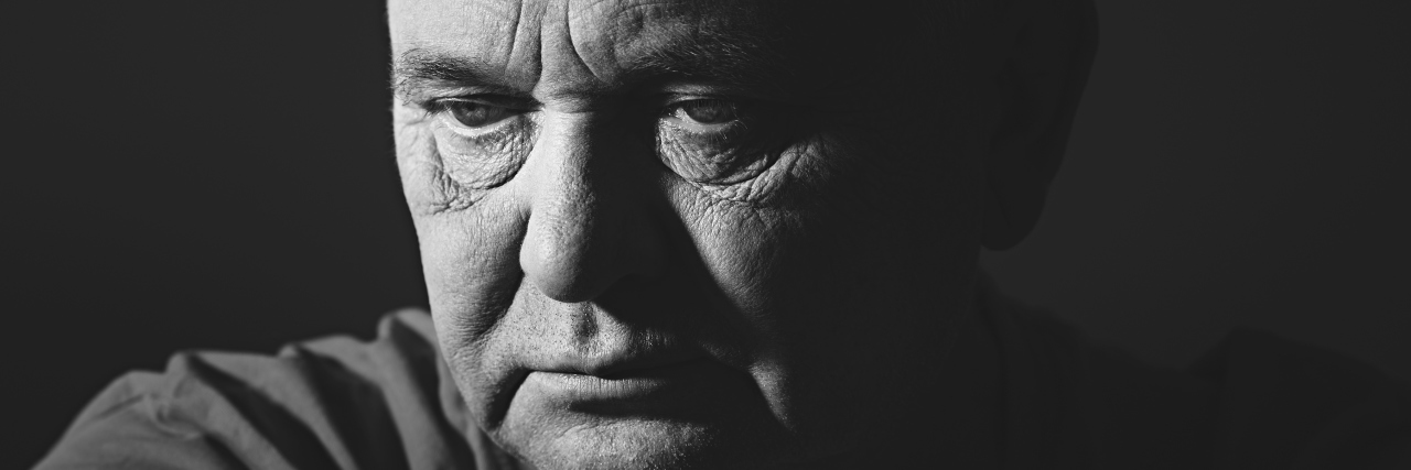 Dealing With Weight Gain Because of Dercum's Disease Close up portrait of aged man wearing t-shirt against black background