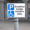 Disabled parking space sign post for badge holders only at shopping mall