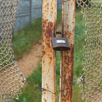 A vintage, old chain link fence with gaps.