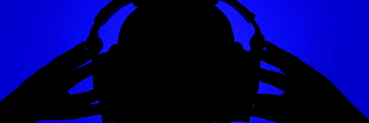 Silhouette of man with headphones on blue background.