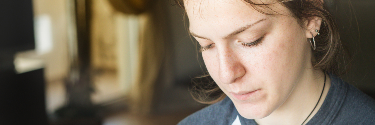 7 Truths I Wish People Knew About Lyme Disease A woman looking down.