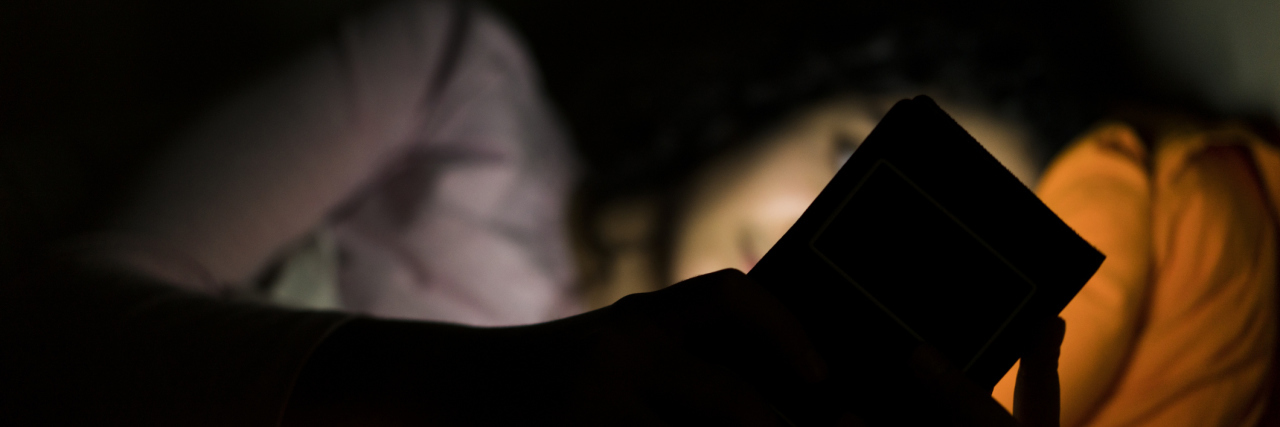 The Simple Text That Changed My Life as Someone With Anxiety close up of woman using smart phone in bed at night