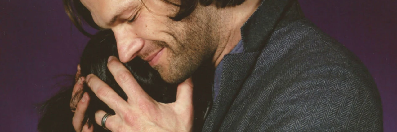 contributor with jared padalecki from tv show supernatural where contributor is hiding her face in his shoulder