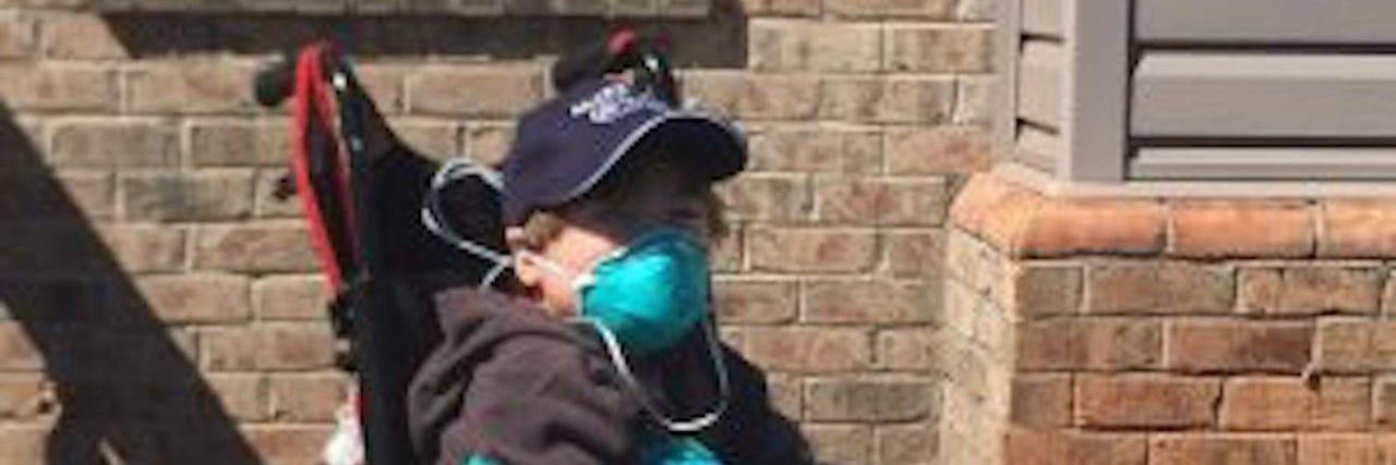 Changing the 'Look Away, Don't Comment' Lesson for Our Kids the author's son in a wheelchair, wearing a mask