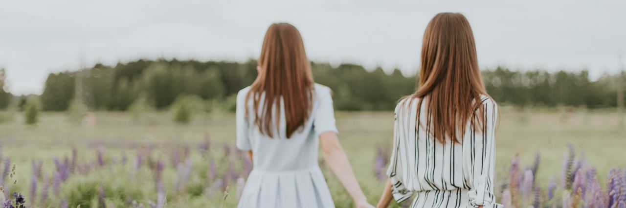 How to Ask Your Friend If They Are Considering Suicide two women holding hands in field of flowers