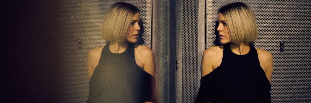 The Best Piece of Advice My Therapist Gave Me About Living With OCD woman looking in mirror