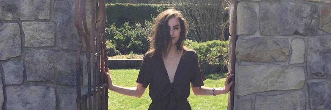 How Taking Chronic Pain Opioids for 5 Years Saved My Life A girl standing in between a gate.