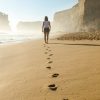 footsteps on sand of beach woman walking away