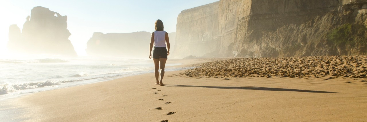 6 Unexpected Symptoms of Summer With Ehlers-Danlos Syndrome and POTS A woman walking alone on a bright summer beach, with her footsteps in the sand behind her as she walks away. 6 Unexpected Symptoms of Summer With Ehlers-Danlos Syndrome and POTS