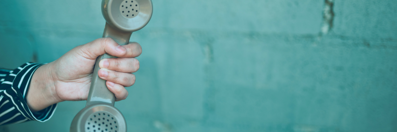 House Passes Bill to Change Suicide Prevention Lifeline to 3 Digits Hand holding a telephone with a cord