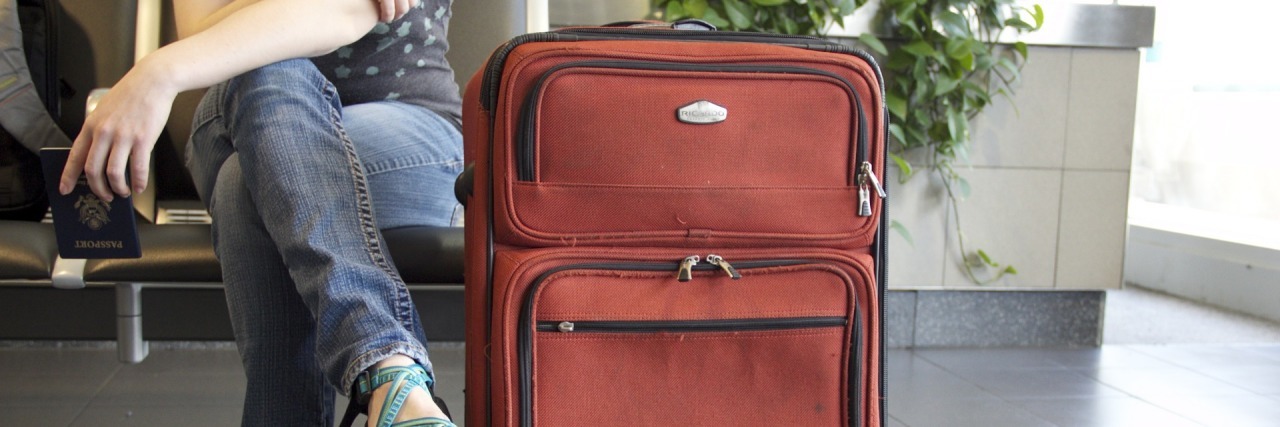 Lessons Learned From My Cancelled Mastectomy woman sitting next to a suitcase