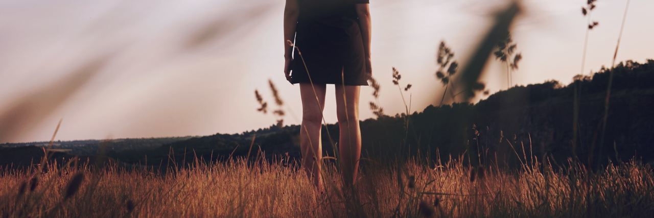 What Is Avoidant Personality Disorder? young woman standing in field alone at sunset