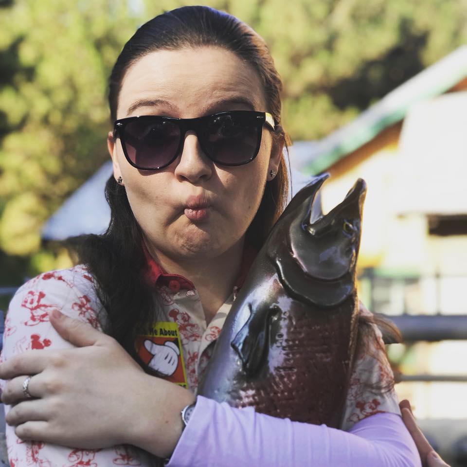 woman wearing sunglasses and posing with a fish
