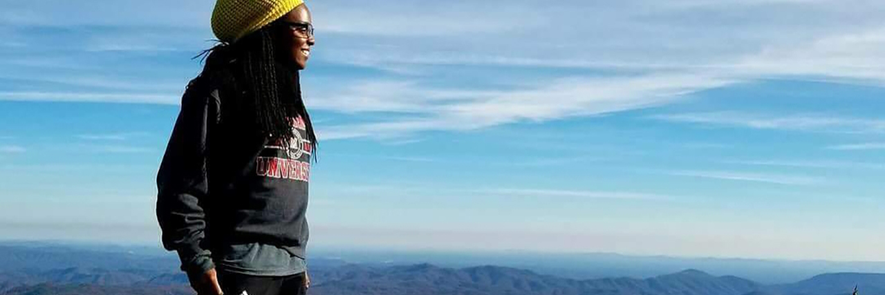 Getting an Adult Autism Diagnosis as an African American Woman Kala standing on a mountain in Nigeria.