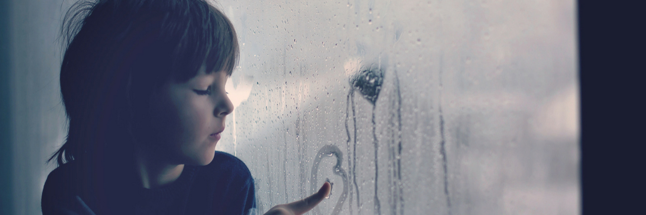 What People With Anxiety Want to Tell Their Younger Selves A young boy looking out a foggy window: 22 Things People With Anxiety Wish They Could Tell Their Younger Selves