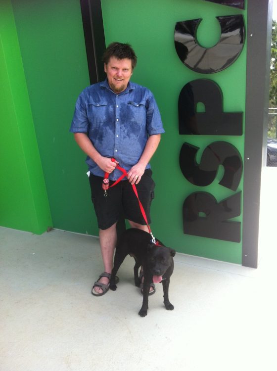 man sanding with dog on a leash